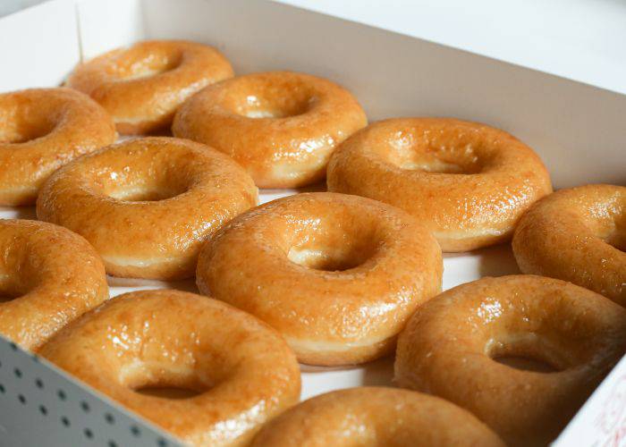 A box of fresh Krispy Kreme donuts, shiny with glaze.